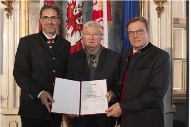 La consegna dell'onorificenza a Karl Gruber (al centro) da parte del presidente altoatesino Arno Kompatscher (sx) e di quello tirolese Günther Platter (dx). Foto: Land Tirol/Die Fotografen