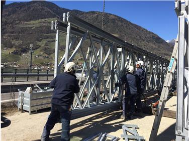 Il ponte provvisorio in metallo allestito a Maia Bassa all’altezza della cooperativa frutticola Cafa consente l’accesso dalla superstrada MeBo al cantiere sulla sponda orograficamente sinistra - Foto: Sistemazione bacini montani sud