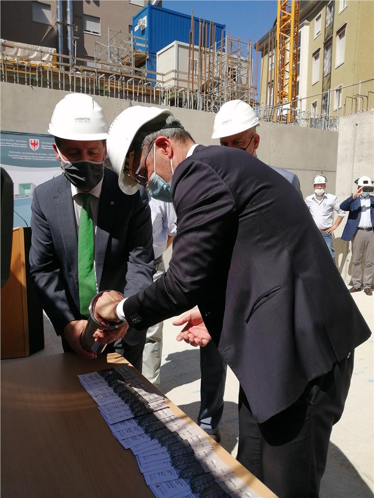 Il presidente della Provincia Arno Kompatscher, l'assessore provinciale all'edilizia Massimo Bessone, inseriscono la pergamena nella prima pietra simbolica del nuovo Palazzo del personale. (Foto: ASP/Igor Cocca)