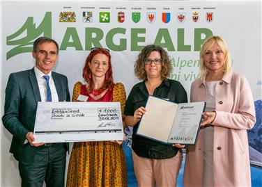 Il vicepresidente Theiner e la minsitra Merk consegnano il premio al progetto altoatesino Book a cook alle promotrici Isabelle Hansen e Angela Wagner (Bayerische Staatskanzlei/Lienert)